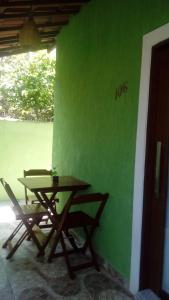 una mesa de madera y sillas junto a una pared verde en Casa em Pipa 2 quartos, en Pipa
