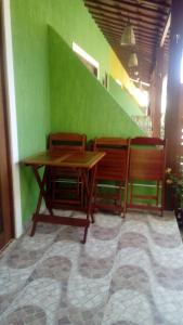 uma mesa e duas cadeiras e uma parede verde em Casa em Pipa 2 quartos em Pipa