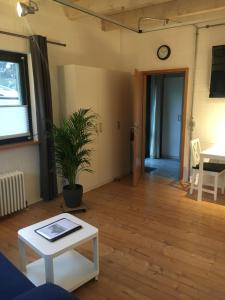 a living room with a table and a clock on the wall at Apartment Reetblick in Kiel