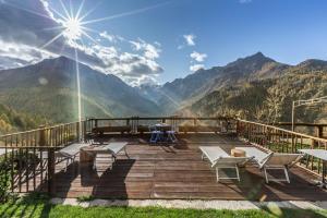 a wooden deck with a view of mountains at Brieis Relais Alpino in Marmora