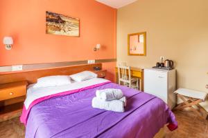 a bedroom with a purple bed and a desk at Hotel Almira in Agia Triada