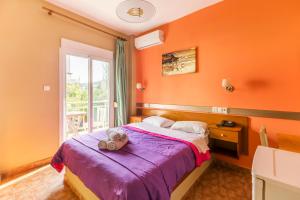 a bedroom with a teddy bear sitting on a bed at Hotel Almira in Agia Triada