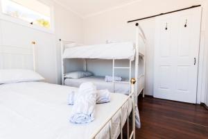 two bunk beds in a bedroom with white walls at Estuary Cottage, Mandurah, Dawesville in Mandurah