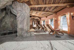 a group of chairs in a room with a stone wall at Hotel Kirchlerhof in Tux