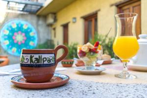 a table with a coffee cup and a glass of orange juice at Kallpa in Cafayate
