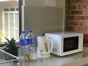 a counter with a microwave and bottles of water at Sarah Guesthouse in Kuala Terengganu