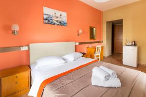 a bedroom with a large bed with orange walls at Hotel Almira in Agia Triada
