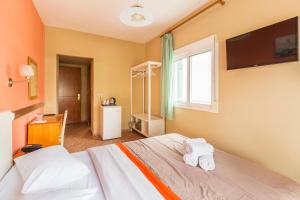 a bedroom with a bed with two towels at Hotel Almira in Agia Triada
