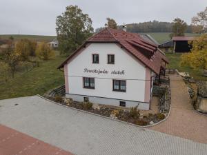 una piccola casa bianca con tetto rosso di Pernštejnův statek a Dívčí Kopy