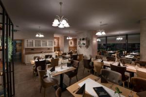 um restaurante com mesas e cadeiras de madeira e luzes em Hostel Vila Pohorje em Slovenj Gradec