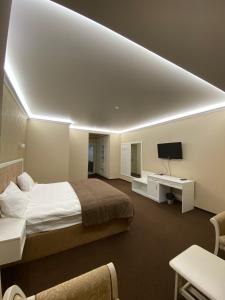 a bedroom with a large bed and a tv at Hotel Obolon in Kyiv