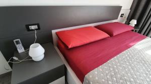 赫拉弗多纳Apartment Panorama的一间卧室配有一张带红色枕头的床和一部电话