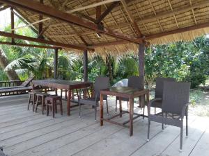 a wooden deck with tables and chairs under a pavilion at Nam Binh Homestay in Ben Tre