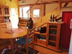 a kitchen with a wooden table and a staircase at Gasthaus Fuchsacker in Degersheim