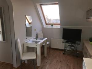 Kleines Zimmer mit einem Tisch und einem TV. in der Unterkunft Le Casa de Jeune in Düsseldorf