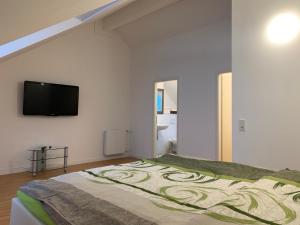 Schlafzimmer mit einem Bett und einem Flachbild-TV in der Unterkunft Wunderschönes 140 qm Reihenhaus im Zeisigring 6, Kaltenkirchen in Kaltenkirchen