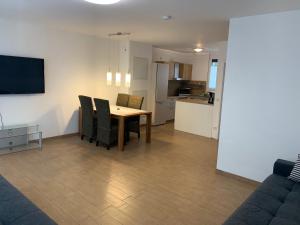 a living room with a table and chairs and a kitchen at Wunderschönes 140 qm Reihenhaus im Zeisigring 6, Kaltenkirchen in Kaltenkirchen