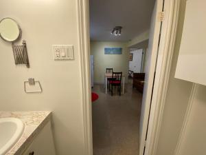 une salle de bain avec un lavabo et une pièce avec une table dans l'établissement Martine & Michel, à Boucherville 43 autres photos