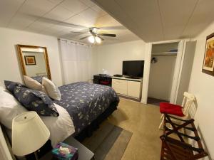 une chambre avec un lit et un ventilateur de plafond dans l'établissement Martine & Michel, à Boucherville