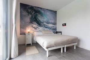 a bedroom with a bed with a painting on the wall at Aqua&Co Bellagio - Eco conscious stay in Bellagio