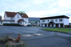 ein Hotel mit einem Parkplatz vor einem Gebäude in der Unterkunft Hotel Linden in Knüllwald