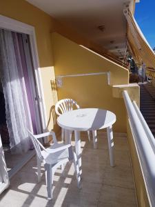 uma mesa branca e cadeiras numa varanda em SUN SAND SEA, PLAYA LAS VISTAS, LOS CRISTIANOS em Los Cristianos
