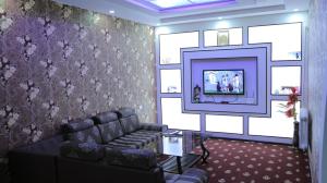 MIRONSHOX GuEST HOUSE في خيوة: غرفة معيشة مع أريكة وتلفزيون بشاشة مسطحة