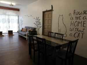 a living room with a table and a cat stencil on the wall at Pino's Place in Kuah
