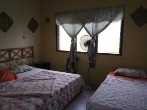 a bedroom with two beds and a window at Room 2 in Mulu