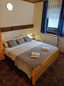 1 dormitorio con 1 cama grande y 2 toallas. en Apartma Kramar Podkoren, en Kranjska Gora