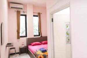 a bedroom with a pink bed and a window at MP Hotel Purwakarta in Purwakarta