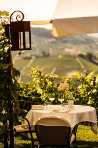 モンフォルテ・ダルバにあるアグリツーリズモ ラ トッリチェッラの白いテーブルクロスとワイングラス付きのテーブル