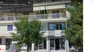 a white building with a balcony on top of it at Dharma Luxury & Spa Apartment in Serres