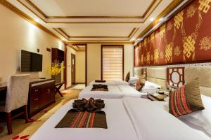Cette chambre comprend 4 lits et une télévision. dans l'établissement Floral Hotel · Shangri-la Blue Sky, à Shangri-La