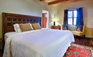 a hotel room with a large bed and a large window at Abiquiu Inn in Abiquiu