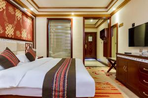 a bedroom with a large bed and a flat screen tv at Floral Hotel · Shangri-la Blue Sky in Shangri-La