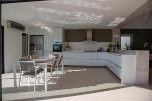 a kitchen with white cabinets and a table and chairs at Villa AKA walking acces to beach in Saint Barthelemy