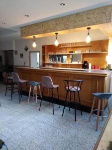 a bar in a restaurant with chairs and a counter at Gite de la Gare in Varzy