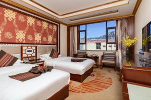 a hotel room with two beds and a large window at Floral Hotel · Shangri-la Blue Sky in Shangri-La