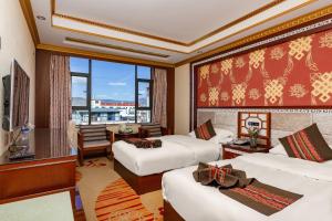 a hotel room with three beds and a large window at Floral Hotel · Shangri-la Blue Sky in Shangri-La