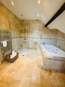 a large bathroom with a tub and a shower at Old Rectory Country Hotel in Crickhowell