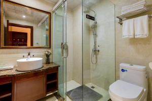 a bathroom with a shower and a toilet and a sink at Floral Hotel · Shangri-la Blue Sky in Shangri-La