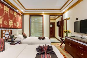 a hotel room with two beds and a flat screen tv at Floral Hotel · Shangri-la Blue Sky in Shangri-La