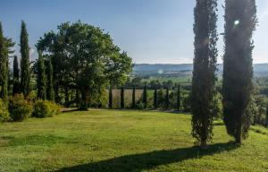 un jardín con árboles y césped y una valla en Agriturismo I Gergoni, en Monteleone dʼOrvieto