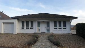 a white house with a driveway in front of it at FeWo Püttlingen in Püttlingen