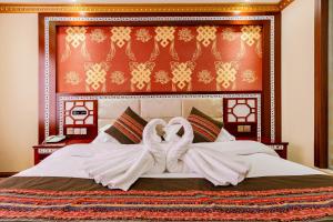 a bedroom with a bed with a towel on it at Floral Hotel · Shangri-la Blue Sky in Shangri-La