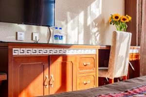 a desk with a sink and a vase of flowers at Floral Hotel · Shangri-la Blue Sky in Shangri-La