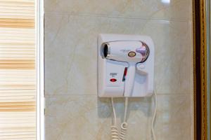 a white hair dryer on a wall in a bathroom at Floral Hotel · Shangri-la Blue Sky in Shangri-La