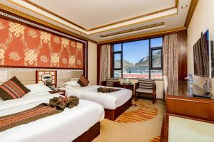 a hotel room with two beds and a window at Floral Hotel · Shangri-la Blue Sky in Shangri-La