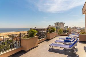 a row of lounge chairs on a balcony overlooking the beach at Hotel Nettunia in Rimini +17 photos